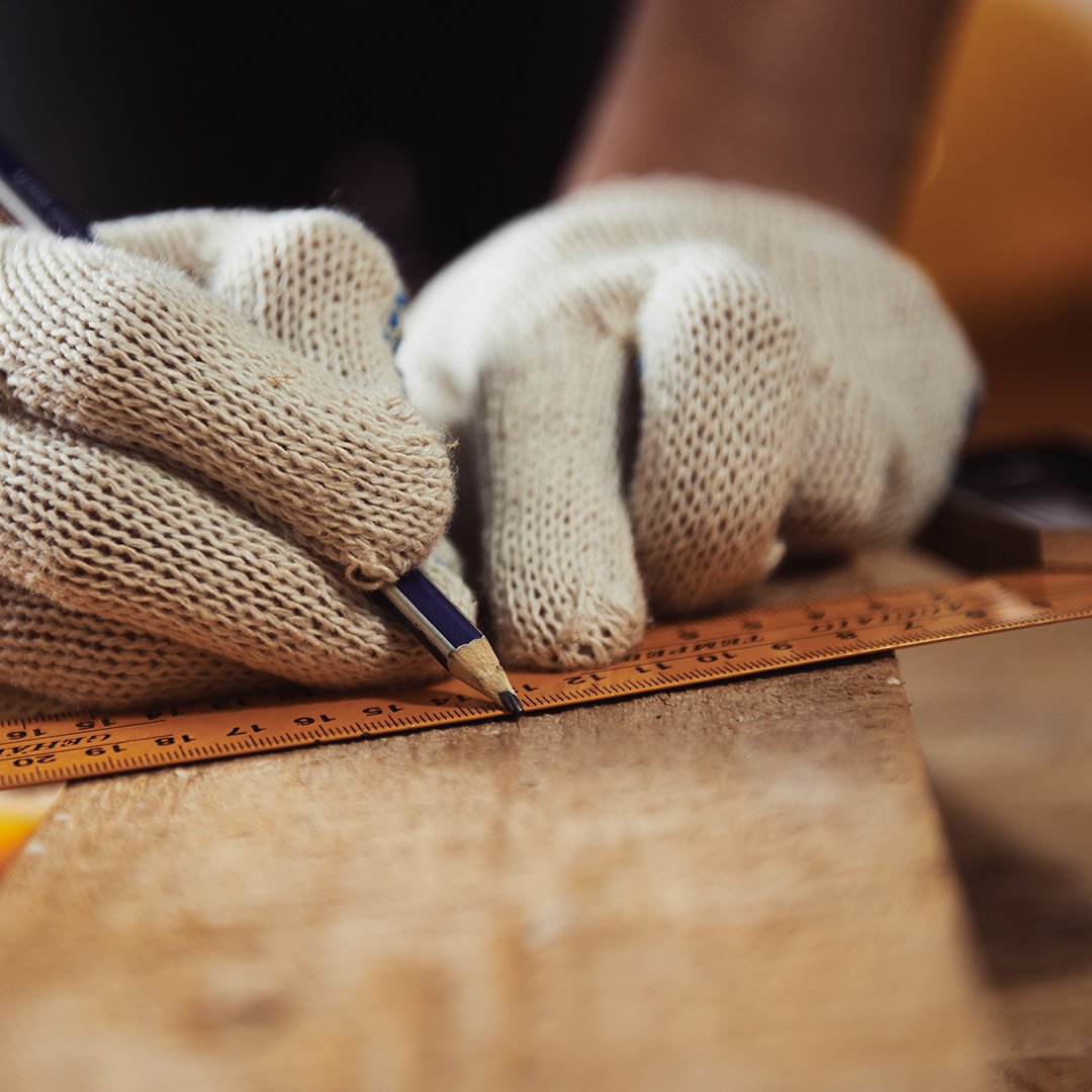 Image of a worker measuring a piece of lumber